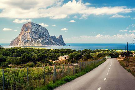 Tranquila carretera ibicenca con el mar al fondo