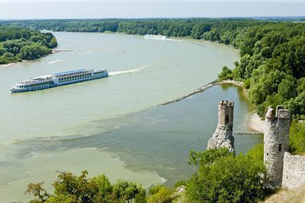 Crucero recorriendo el Danubio junto a las ruinas del castillo de Devín en Eslovaquia