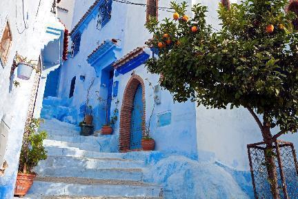 Chefchauén, vista de las fachadas azules en calle con naranjo, Marruecos