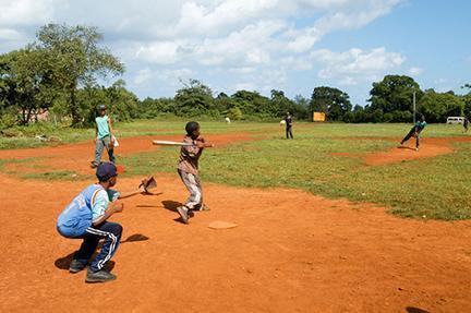 Muchachos jugando en la calle al beisbol