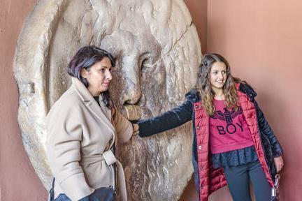 Turistas introduciendo sus manos en la Bocca della Veritá de Roma