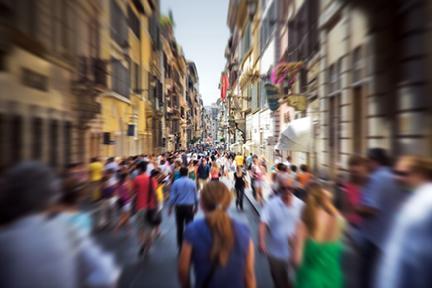 Calle siciliana llena de personas caminando por ella