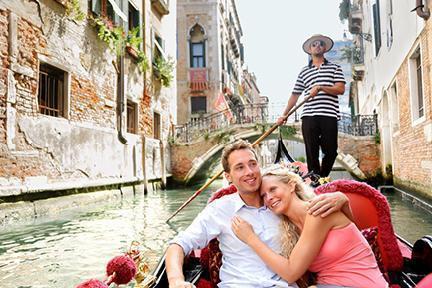 Pareja de enamorados disfrutando un paseo en góndola por los canales de Venecia