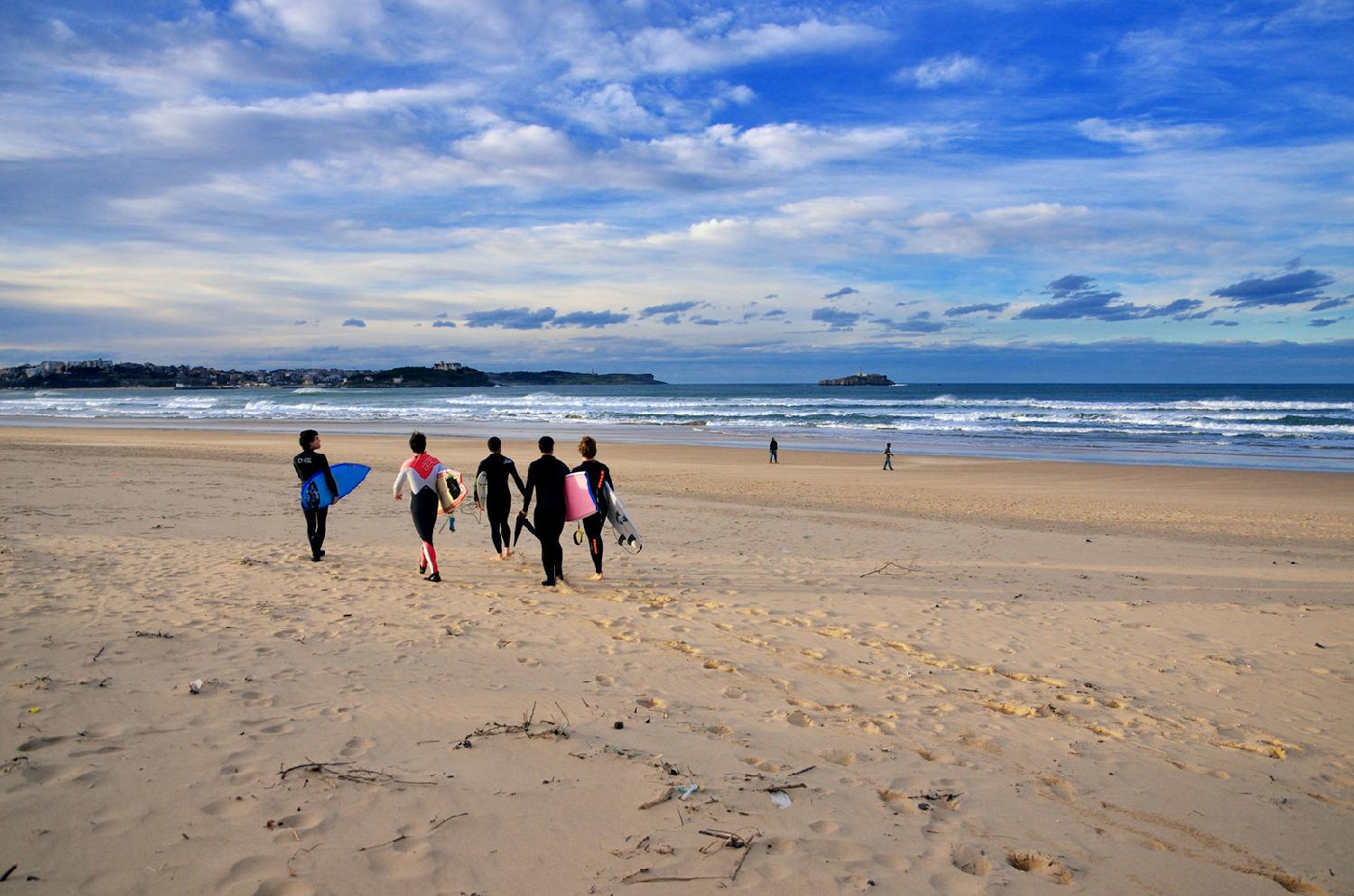 Surfistas caminando por la playa de Somo