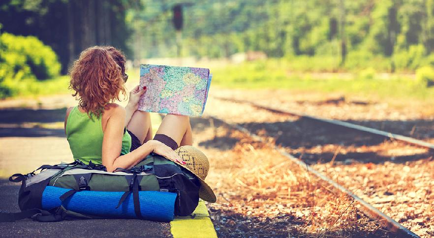 Joven esperando con su equipaje al próximo tren en su viaje Interrail