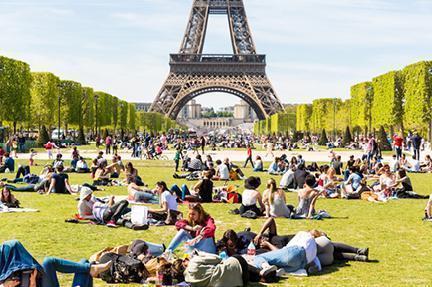 Parisinos disfrutando del buen tiempo en el Campo de Marte junto a la Torre Eiffel