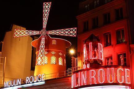 Carteles iluminados por la noche del famoso Moulin Rouge de París